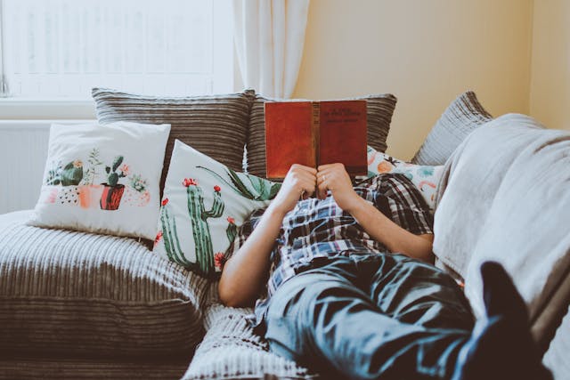 man laying on couch reading